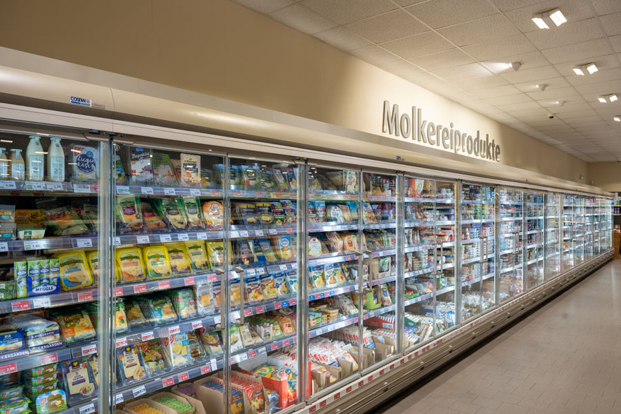 Lange Kühlregalreihe mit Molkereiprodukten im Supermarkt.