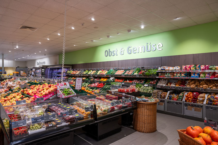 Supermarkt-Obst- und Gemüseabteilung mit frischen Auslagen.